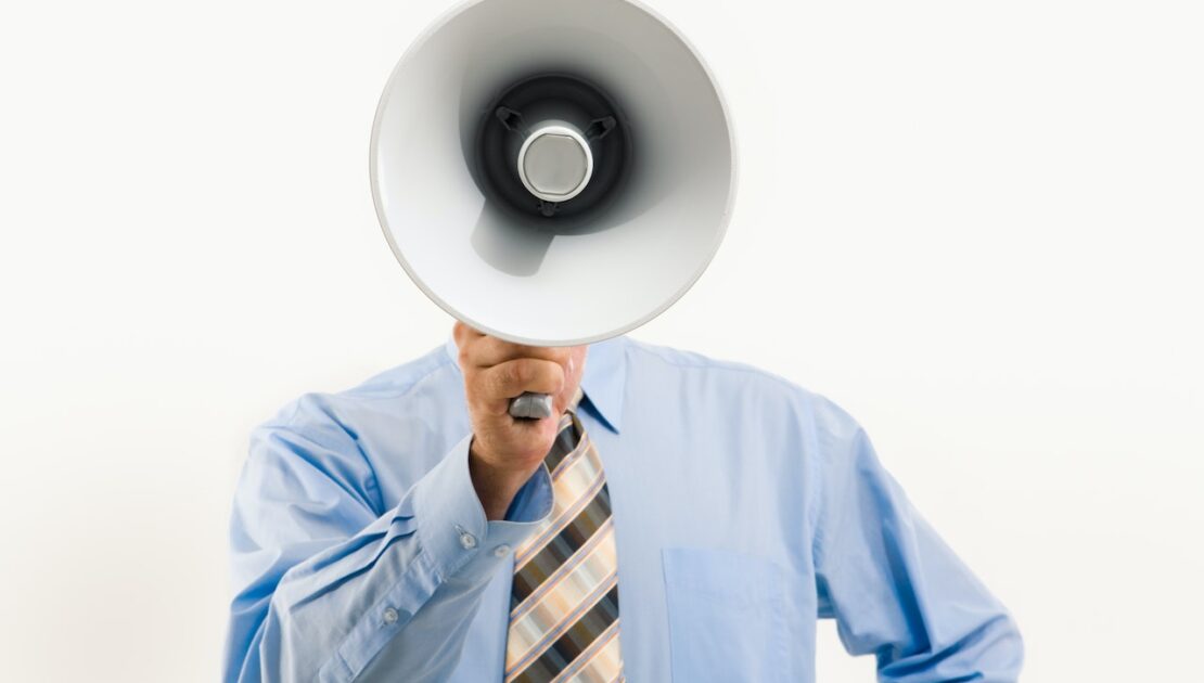 Image of a man with a megaphone making an accouncement